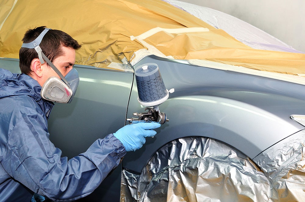 Technician painting car exterior Bentley Buick GMC in Huntsville AL